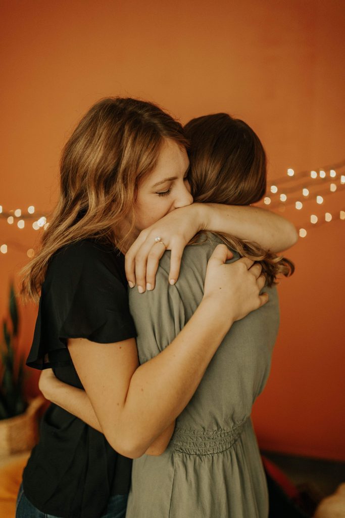 Two girls cuddling and garland with bulbs