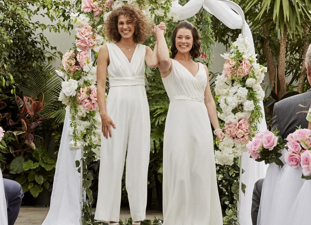 Two brides are happy holding hands and smiling