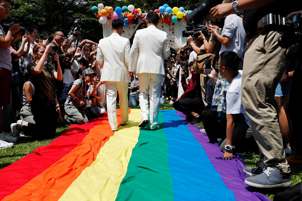 two men walking holding hands at their wedding ceremony