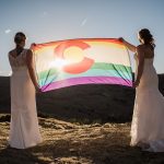 Two brides with rainbow flag