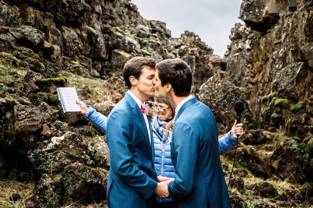 Two grooms kissing at wedding