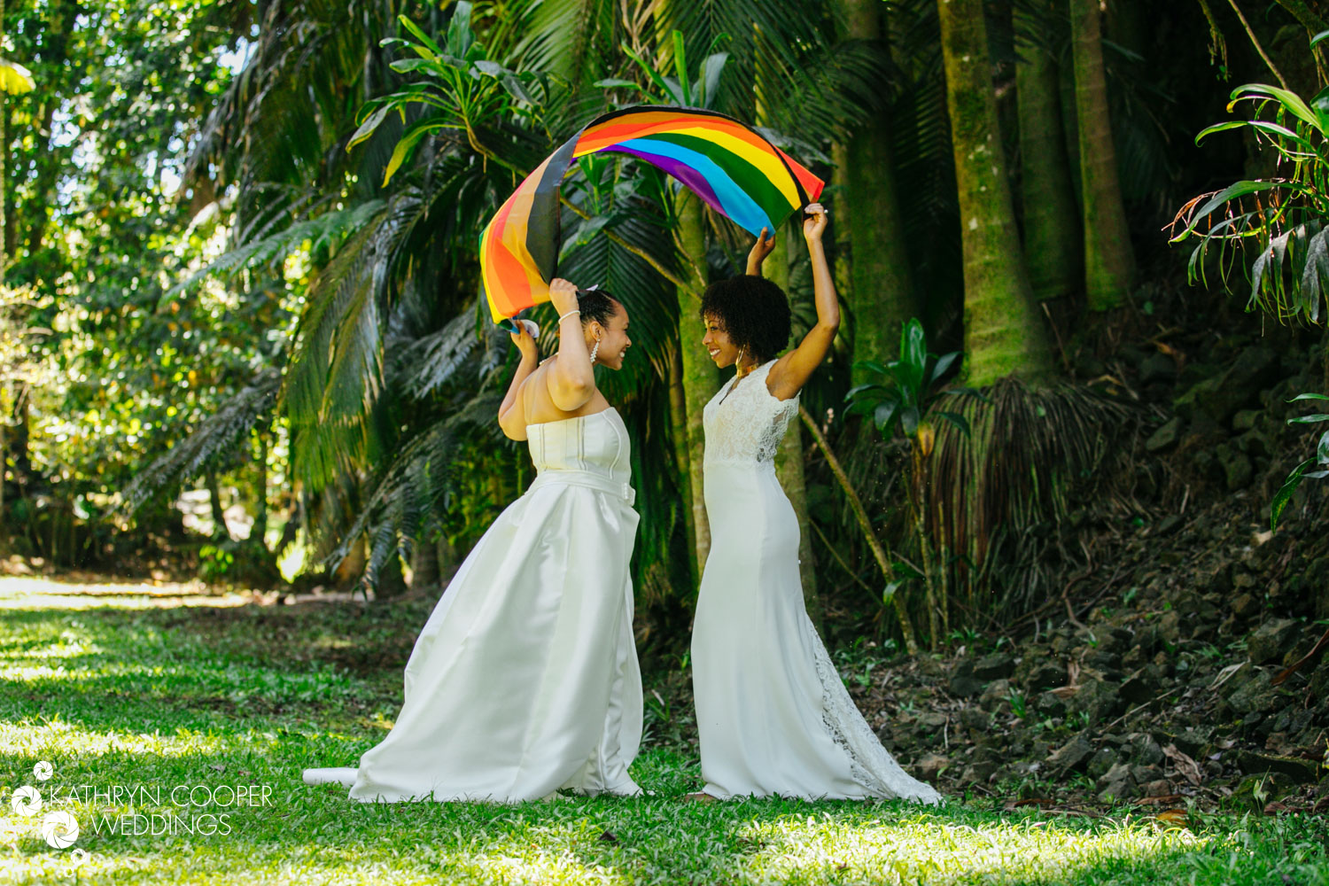 Two brides with rainbow flag